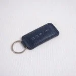 جاکلیدی چرمی سورمه‌ای با طرح بافت طبیعی و دوخت منظم برند دراتی