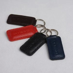 چهار جاکلیدی چرمی در رنگ‌های متنوع مشکی، سورمه‌ای، قرمز و قهوه‌ای