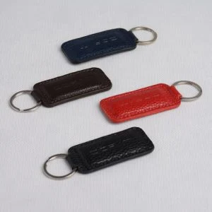 نمای بالا از جاکلیدی‌های چرمی رنگی با حلقه استیل و چرم بافت‌دار طبیعی