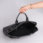 فضای داخلی کیف چرم مشکی با آستر پارچه‌ای و محفظه لپ‌تاپ