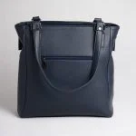 کیف چرم زنانه آنا در دست مدل با استایل حرفه‌ای و رنگ سورمه‌ای خاص