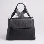 کیف چرم زنانه ایستاده روی زمینه سفید با نور ملایم