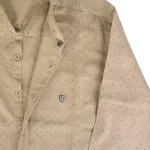 نمای نزدیک یقه و دکمه رنگ نخودی خال خالی